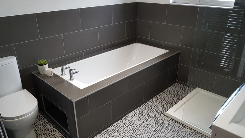 Bathroom installation with a bath and bespoke tiling
